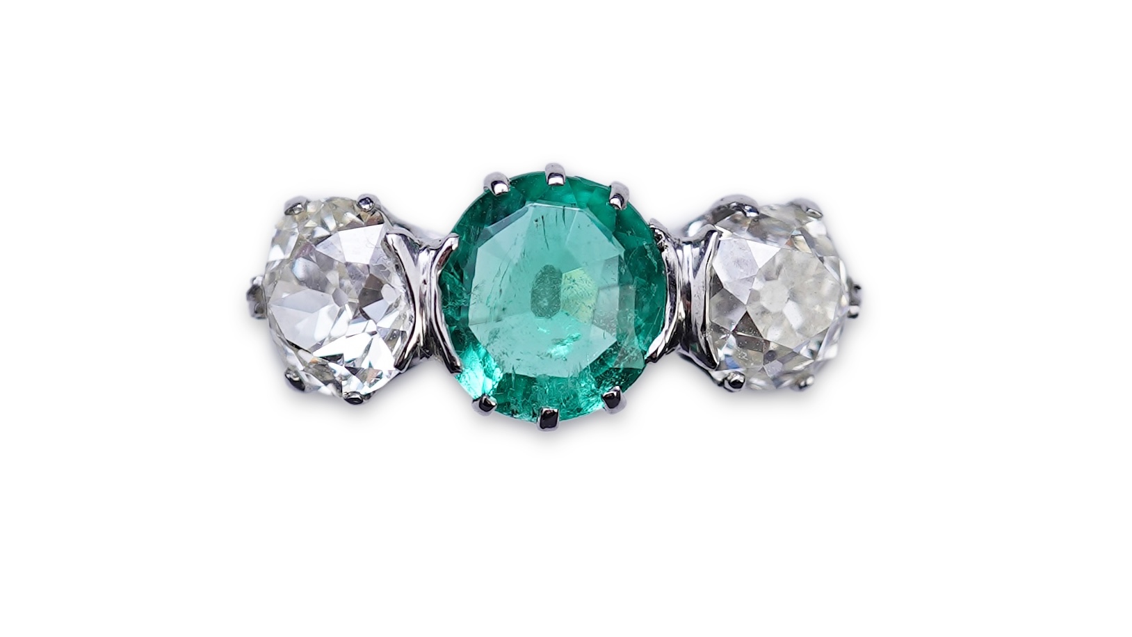 An attractive emerald and diamond three-stone ring, early 20th century